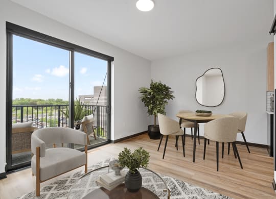 a living room with a table and chairs and a balcony