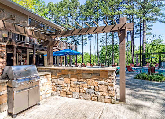 Outdoor grill and picnic area with stainless steel grills and covered seating at pet-friendly Stratford Ridge Apartments in Marietta, GA, ideal for gatherings and cookouts.
