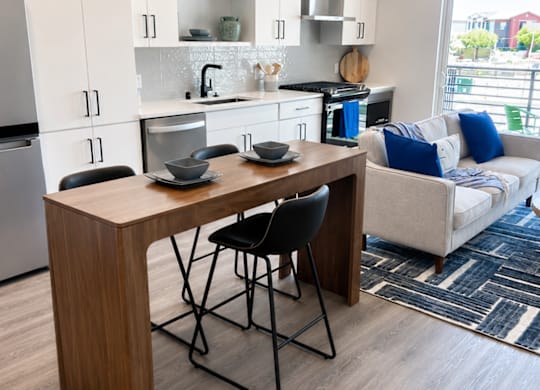 A kitchen with a table and chairs in front of a window.