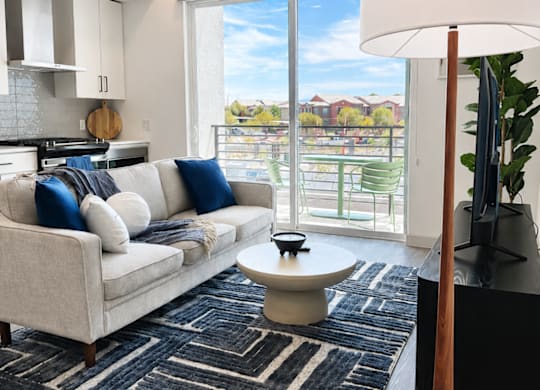 A living room with a white couch and a black and white rug.