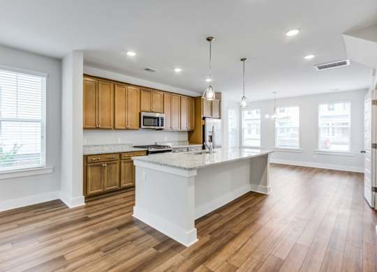 a kitchen and living room with hardwood floors and white walls