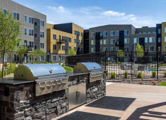 a patio with two grills in front of an apartment building