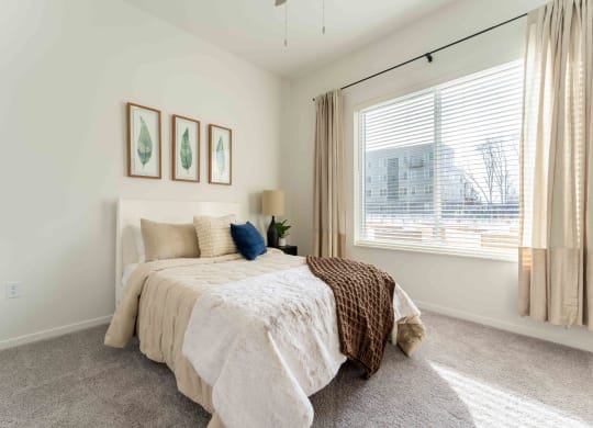a bedroom with a bed and a large window
