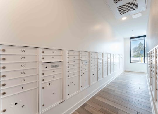 a row of lockers in a room with wooden floors and a window