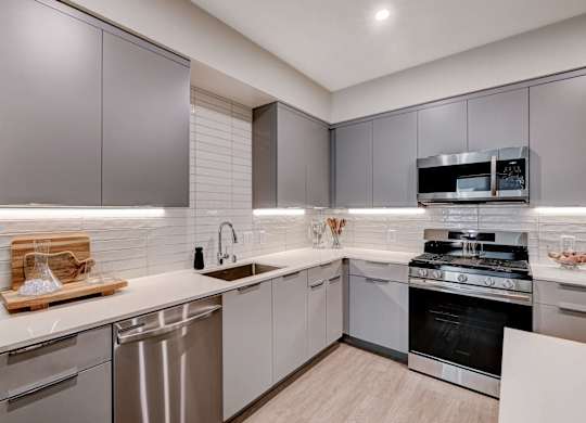 A modern kitchen with stainless steel appliances and wooden countertops.