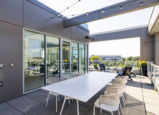 A white table with chairs is set up on a patio.