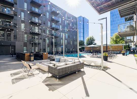 A modern outdoor seating area with a pool and lounge chairs.