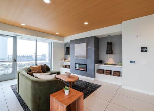 A modern living room with a green couch and a wooden coffee table.