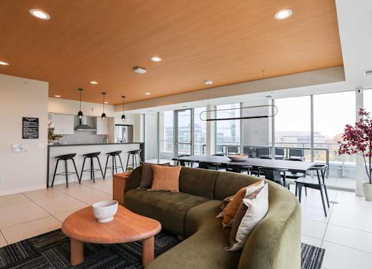 A modern living room with a green couch and a wooden table.