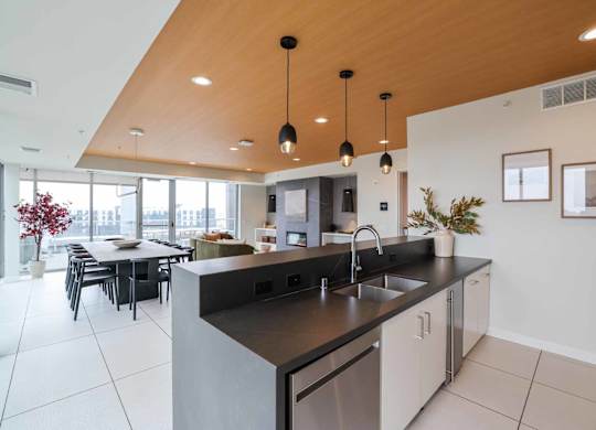A modern kitchen with a large island and pendant lights.