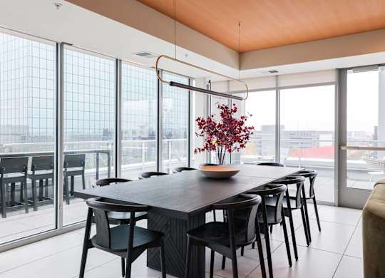 A modern dining room with a long table and chairs.