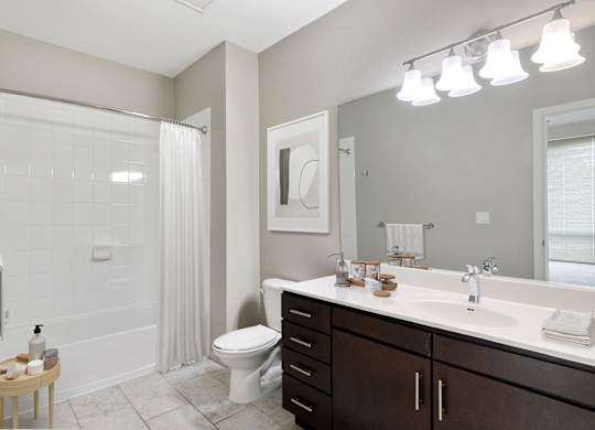 bathroom with dark wood vanity and tub shower