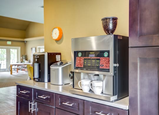 a coffee bar in a hotel room with a coffee machine and coffee cups on the counter