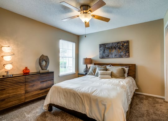 a bedroom with a large bed and a ceiling fan