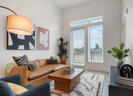 2-BR Apartments in Wheat Ridge, CO - Parallel - Living Room with Couch, Chair, Area Rug, Coffee Table, Large Window, Luxury Plank Flooring.
