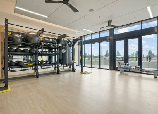 a large room with glass windows and a large metal structure with weights and other equipment in it
