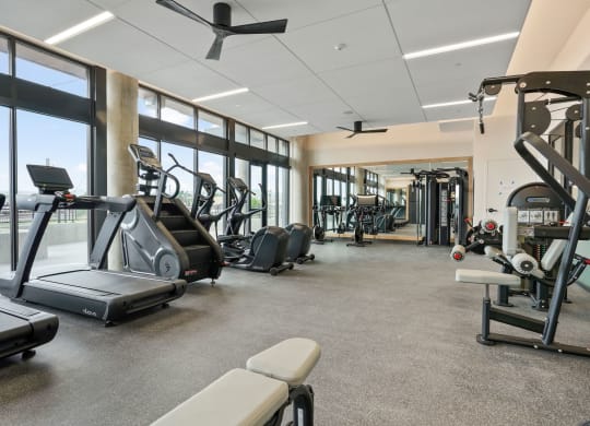 Studios In Wheat Ridge, CO - The Parallel - Fitness Center Equipped With Cardio Machines, Strength Training Machines, Full Body Mirror, And Floor To Ceiling Windows