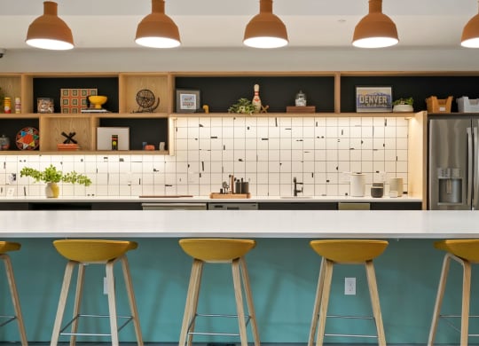 a kitchen with a white counter top and yellow and blue stools