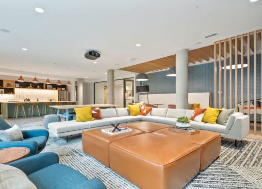Apartments For Rent In Wheat Ridge, CO - The Parallel - Clubroom With Chef’s Kitchen, TV Lounge, Game Area, Couches, Lounge Chairs, and Screen Projector