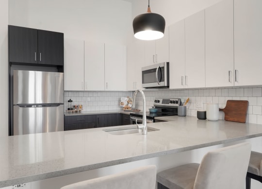 a kitchen with a counter top and a stainless steel refrigerator