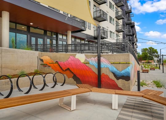a bench with a mural on the side of a building