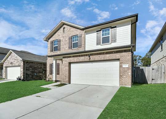 A two-story house with a garage is located in a residential area.
