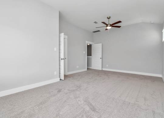 Heights, Houston, TX, Rental Homes - The Crossing at Timbergrove - Spacious Bedroom with Carpet Flooring, and a High Ceiling with a Ceiling Fan.