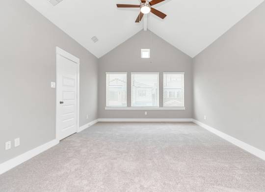 an empty bedroom with a ceiling fan and three windows
