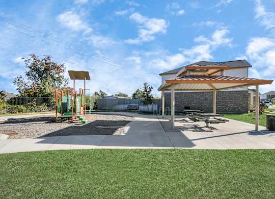 A playground with a swing set and a picnic pavilion.