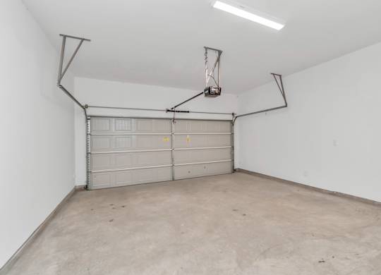 the inside of a garage with a white wall and a white garage door