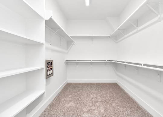 a walk in closet with white walls and white shelves