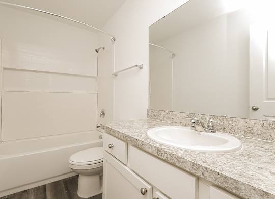 A white bathroom with a sink, toilet, and bathtub.