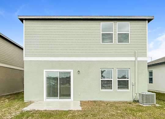 A house with a grey siding and a white door and windows.