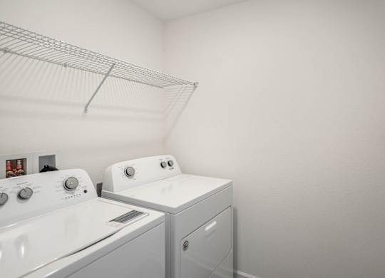 A white laundry room with a washer and dryer.