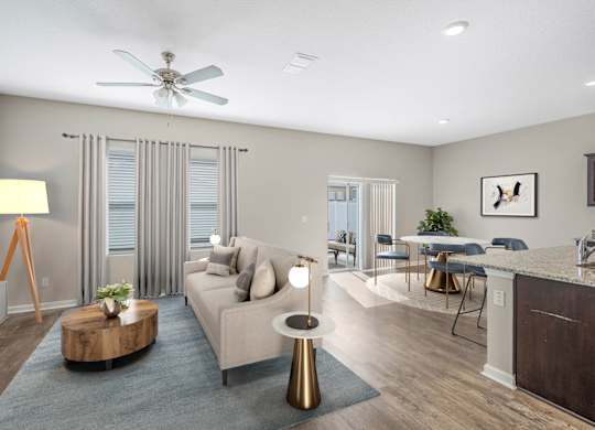 A modern living room with a grey sofa, a wooden coffee table, and a ceiling fan.