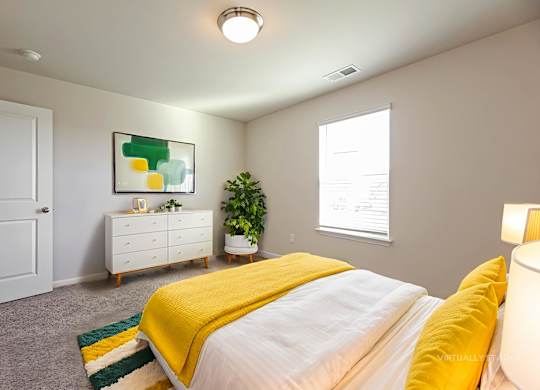 A bedroom with a bed, dresser, and a painting on the wall.