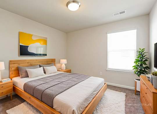 A bedroom with a bed, nightstands, and a painting on the wall.