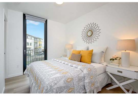 Apartments in Seattle - Inspire Fremont - Bedroom with Hardwood Style Flooring, Glass Door to Private Balcony/Patio, and Overhead Lighting