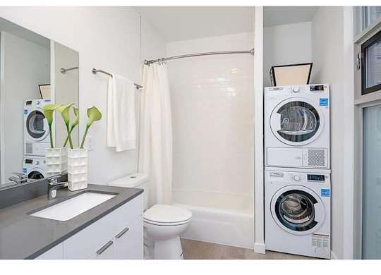 Apartments For Rent Fremont, WA - Inspire Frmont - Bathroom With A Garden-Style Tub, High Ceilings, And An In-Unit Washer And Dryer.