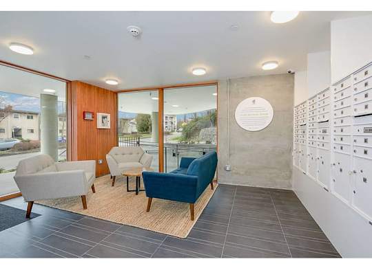 Apartments in Seattle, WA - Inspire Fremont - Lobby with Mail Slots, Floor-to-Ceiling Windows, and a Seating Area