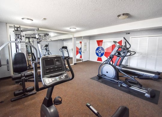 a gym with exercise machines and other equipment in a room with flags