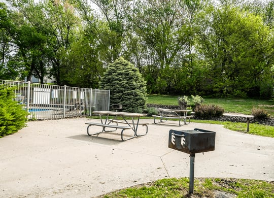 a picnic table with a grill on apartment property