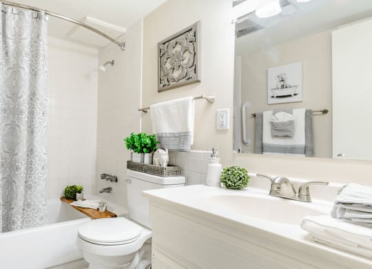 a white bathroom with a white toilet and tub and a white sink