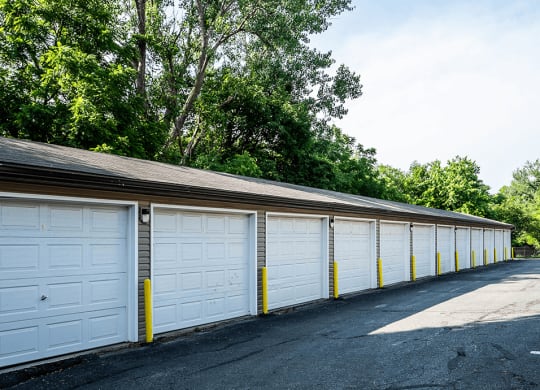 a row of garages with white doors and a gray roof