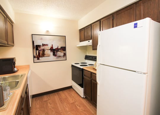 apartment kitchen with a refrigerator and stove top oven