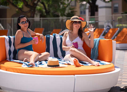 Two women are sitting on a sun lounger.