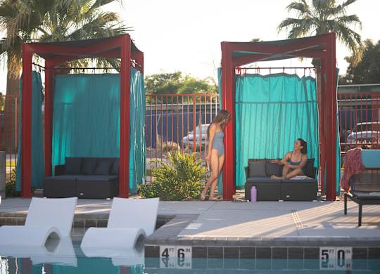 A woman in a bikini stands by a pool.