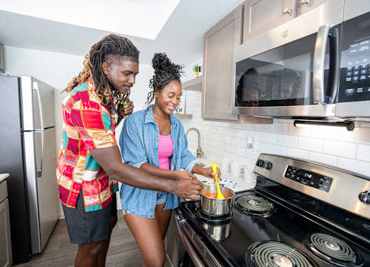 Two people cooking in a modern kitchen.