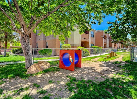 A colorful circular object is placed on a grassy area in front of a building.