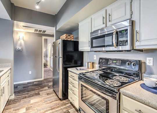 A kitchen with a black refrigerator and stove.